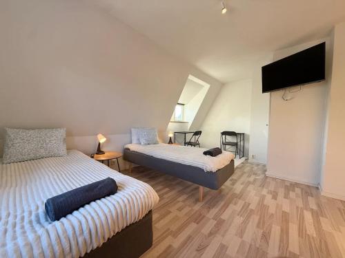 a bedroom with two beds and a flat screen tv at Workers Big Villa - 5 BR - 2 Bath - 10 min to Volvo in Gothenburg