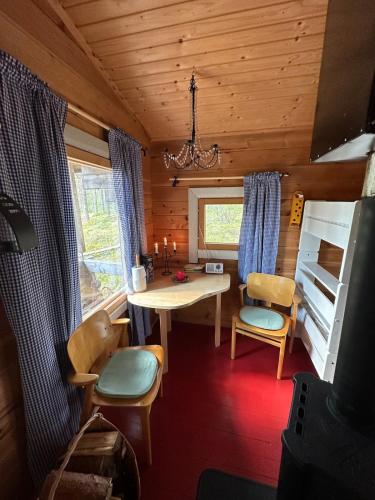 a room with a table and chairs in a cabin at Forestry cabin and sauna cabin in Halmevaara