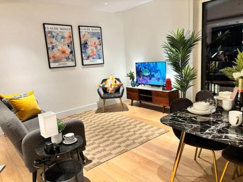 a living room with a couch and a table at Luxury 2BR- Sleeps 5- Westfield Apartment- 3 min to station- Perfect for Families Shopping in London