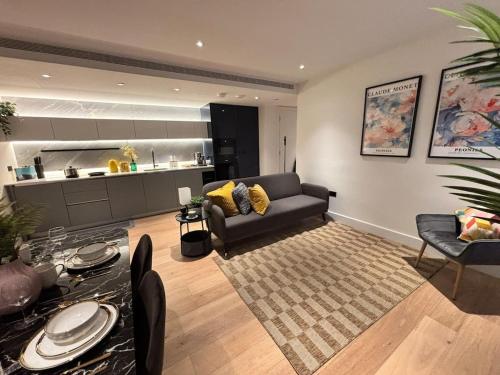a living room with a couch and a kitchen at Luxury 2BR- Sleeps 5- Westfield Apartment- 3 min to station- Perfect for Families Shopping in London
