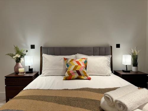 a bedroom with a large bed with two night stands at Luxury 2BR- Sleeps 5- Westfield Apartment- 3 min to station- Perfect for Families Shopping in London