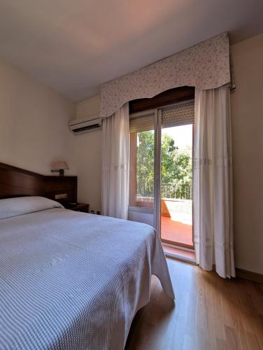 a bedroom with a bed and a large window at Hotel Anabel Baza in Baza