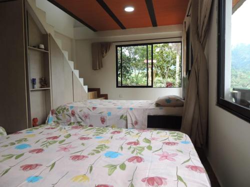 En eller flere senge i et værelse på Cabaña Manaos Salento