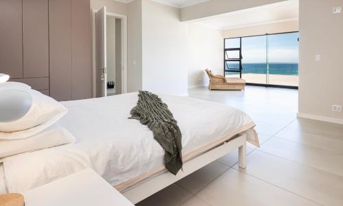 a bedroom with a bed and a view of the ocean at Escape to Paradise in Mossel Bay