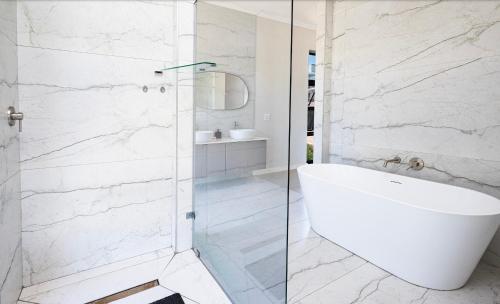 a bathroom with a white tub and a glass shower at Escape to Paradise in Mossel Bay
