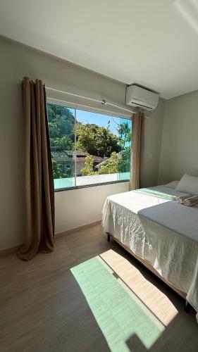 a bedroom with a bed and a large window at Hospedaje MorroSP in Morro de São Paulo