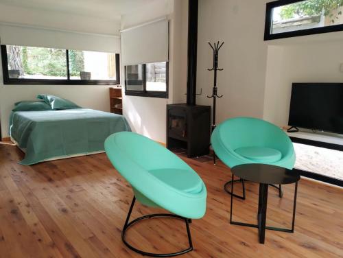 a bedroom with two green chairs and a bed at Big Sur in Mar Azul