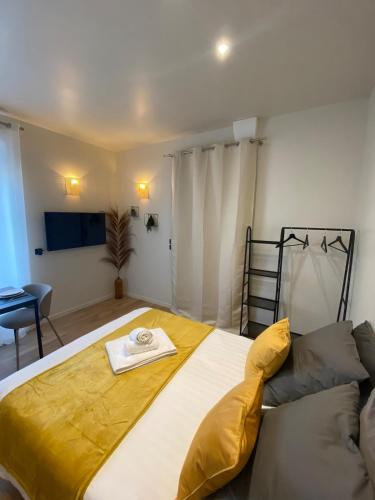 a bedroom with a large bed with a yellow blanket at Le Cocon d'Oberthur - Proche Thabor in Rennes