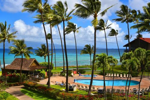 Blick auf ein Resort mit Palmen und das Meer in der Unterkunft Papakea E407 in Kahana