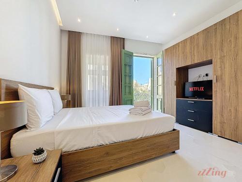 a bedroom with a large bed and a television at Malta Rooftop Villa with Private Plunge Pool & BBQ in Hal Ghaxiak
