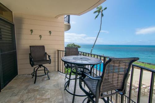 un balcone con tavolo e sedie e l'oceano di Kahana Reef 208 a Kahana