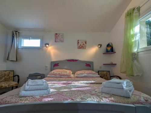 Un dormitorio con una cama con toallas. en Chambres d'hôtes Anne, Marie Davaillon, Chambre Cerise, en Châtillon-sur-Indre