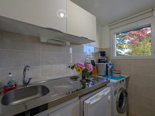 una cocina con fregadero y un jarrón de flores en la encimera en Chambres d'hôtes Anne, Marie Davaillon, Chambre Cerise, en Châtillon-sur-Indre