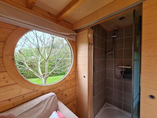 a bathroom with a round window and a shower at Le Carré d'Etoiles / Domaine de la Crapaudine in Rosnay
