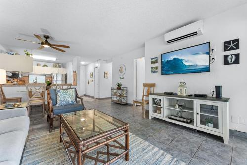 un soggiorno con un divano e una TV a parete di Kihei Akahi B102 a Wailea