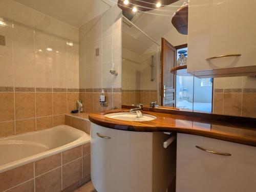een badkamer met een wastafel, een bad en een tubermottermott bij Chambre "Bleue", Les Gabettes in Velles