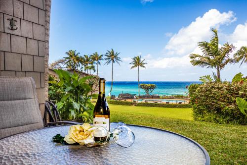 una bottiglia di vino su un tavolo con vista sull'oceano di Polynesian Shores 112 a Kahana