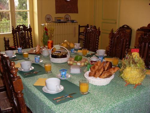 une table avec une nappe avec du pain et du jus d'orange dans l'établissement Chambre "Bleue", Le Priouzé, à Chézelles