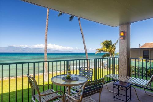 un balcon avec une table et des chaises et l'océan dans l'établissement Papakea A206, à Kahana