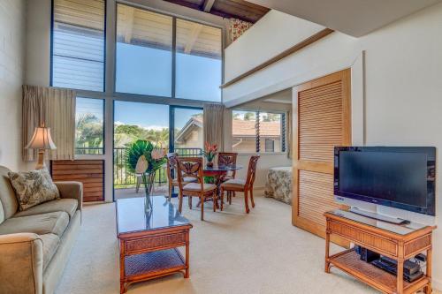 a living room with a couch and a tv at Hono Kai C8 in Wailuku