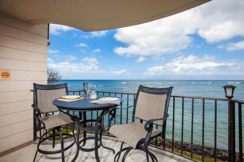a balcony with a table and chairs and the ocean at Kahana Reef 321 in Kahana