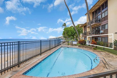 a swimming pool next to the beach at a resort at Hono Kai A7 in Kihei