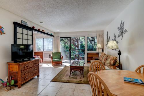 a living room with a tv and a table at Hono Kai B15 in Maalaea