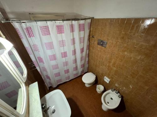 ein Badezimmer mit Dusche, Toilette und Waschbecken in der Unterkunft Hotel General Paz in Villa Carlos Paz