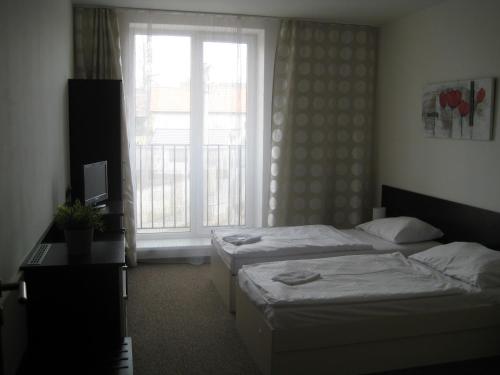 Una habitación de hotel con dos camas y una ventana. en Penzion Nad Zámeckou zdí, en Trhový Štěpánov