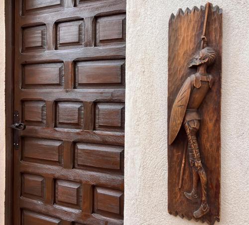 una porta di legno con una statua accanto di Casa de La Canita a Guadamur