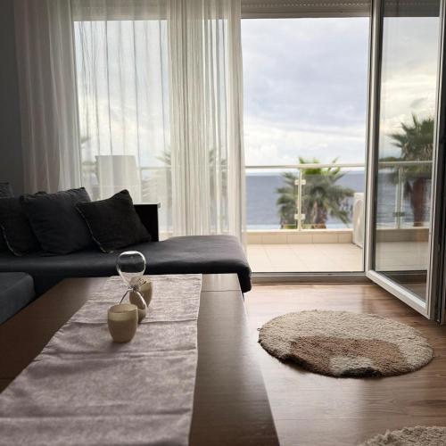 ein Wohnzimmer mit Sofa und großem Fenster in der Unterkunft M&I Apartment in Sarandë