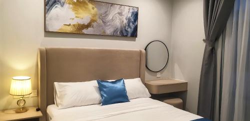 a bedroom with a bed with a blue pillow on it at HADU Hotel & Café Phu Quoc in Phú Quốc