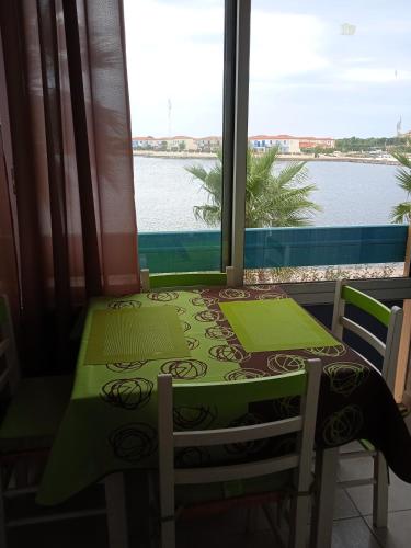 une table et des chaises avec vue sur l'eau dans l'établissement Le Barcarès, au Barcarès