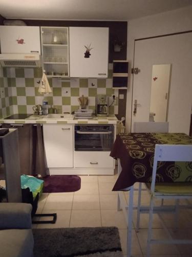 une cuisine avec une table et une cuisine avec une cuisinière dans l'établissement Le Barcarès, au Barcarès