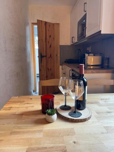 Alpenfels Apartments - Zwieselstein في سولدن: طاولة مع كأسين وزجاجة من النبيذ