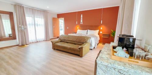 ein großes Hotelzimmer mit einem Bett und einer Couch in der Unterkunft Swakopmund Central Garden Guest House in Swakopmund
