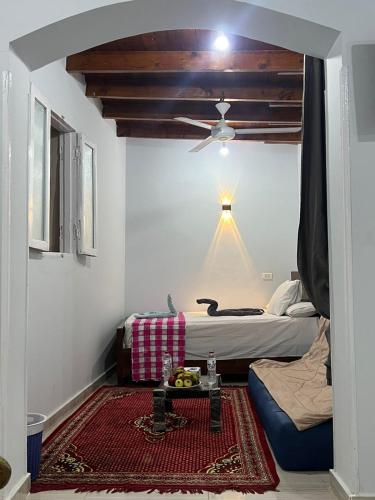 a bedroom with two beds and a ceiling fan at Nile Flower Guesthouse in Luxor