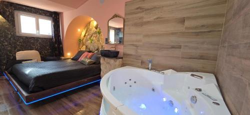 イエールにあるLX187 Ecrin d'Amour jacuzzi privé - cœur de Hyèresのバスルーム(バスタブ付)、ベッド1台が備わります。