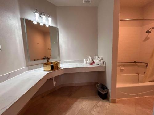 Un baño con lavabo, espejo y bañera. en SureStay by Best Western Morgan Hill, en Morgan Hill