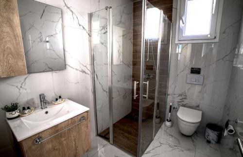 a bathroom with a shower and a sink and a toilet at Spacious & Bright 2BR Apartment, 5min to Beach in Boghaz