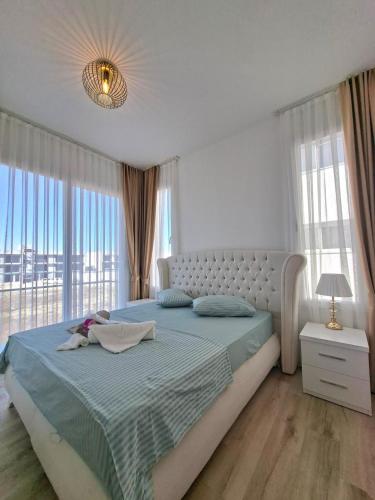 a bedroom with a large bed with a large window at Spacious & Bright 2BR Apartment, 5min to Beach in Boghaz