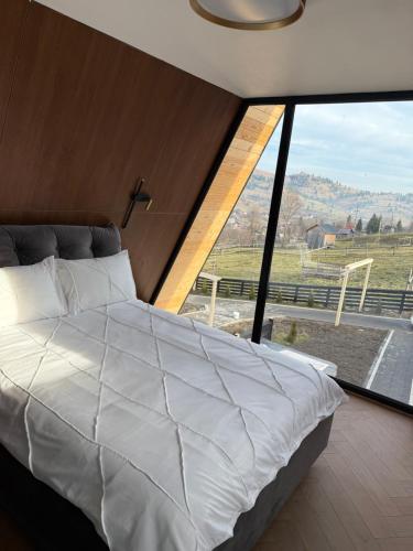 a bedroom with a large bed and a large window at Elis Village in Sadova