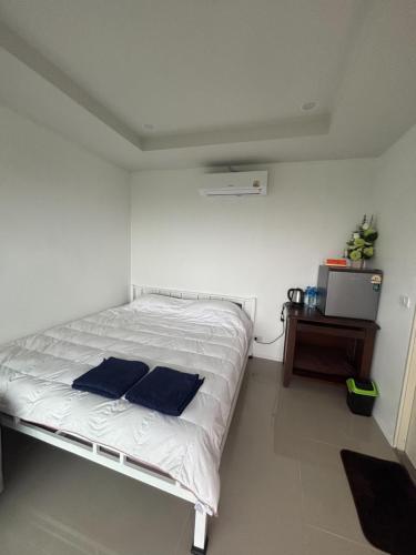 a bedroom with a bed with two blue pillows on it at Mong Do Lay Baan Sea View in Ban Ao Makham