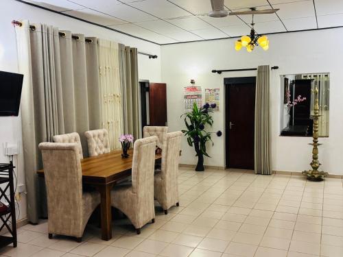 een eetkamer met een houten tafel en stoelen bij Browns Hill Matara in Matara