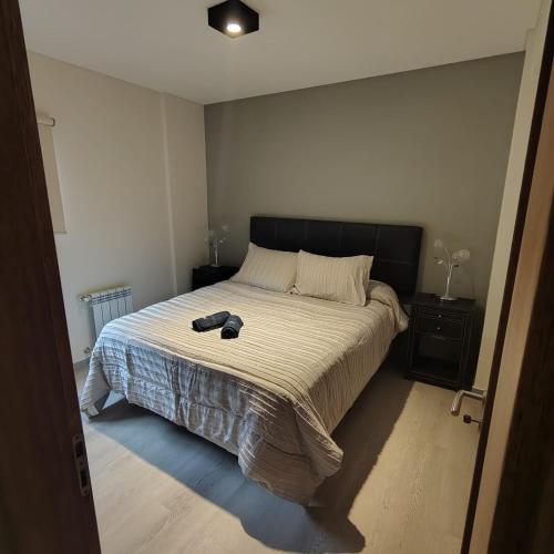 una camera da letto con un letto con un paio di scarpe sopra di departamento premium de 3 Ambientes a Pinamar