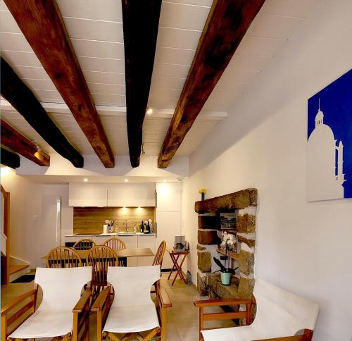 a dining room and kitchen with wooden beams at Le clos du prieuré - Les Gîtes de la Côte d'Amour in Batz-sur-Mer