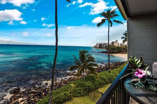 d'un balcon avec vue sur l'océan et les palmiers. dans l'établissement Noelani 309, à Kahana