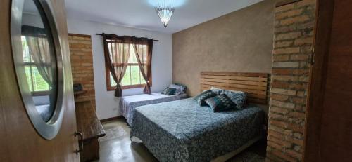 a bedroom with two beds and a mirror at Home 013 in São Vicente