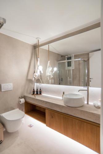 a bathroom with a sink and a toilet and a mirror at 14 luxury apartment in Preveza