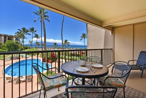 a balcony with a table and chairs and a pool at Hale Ono Loa 203 in Kahana